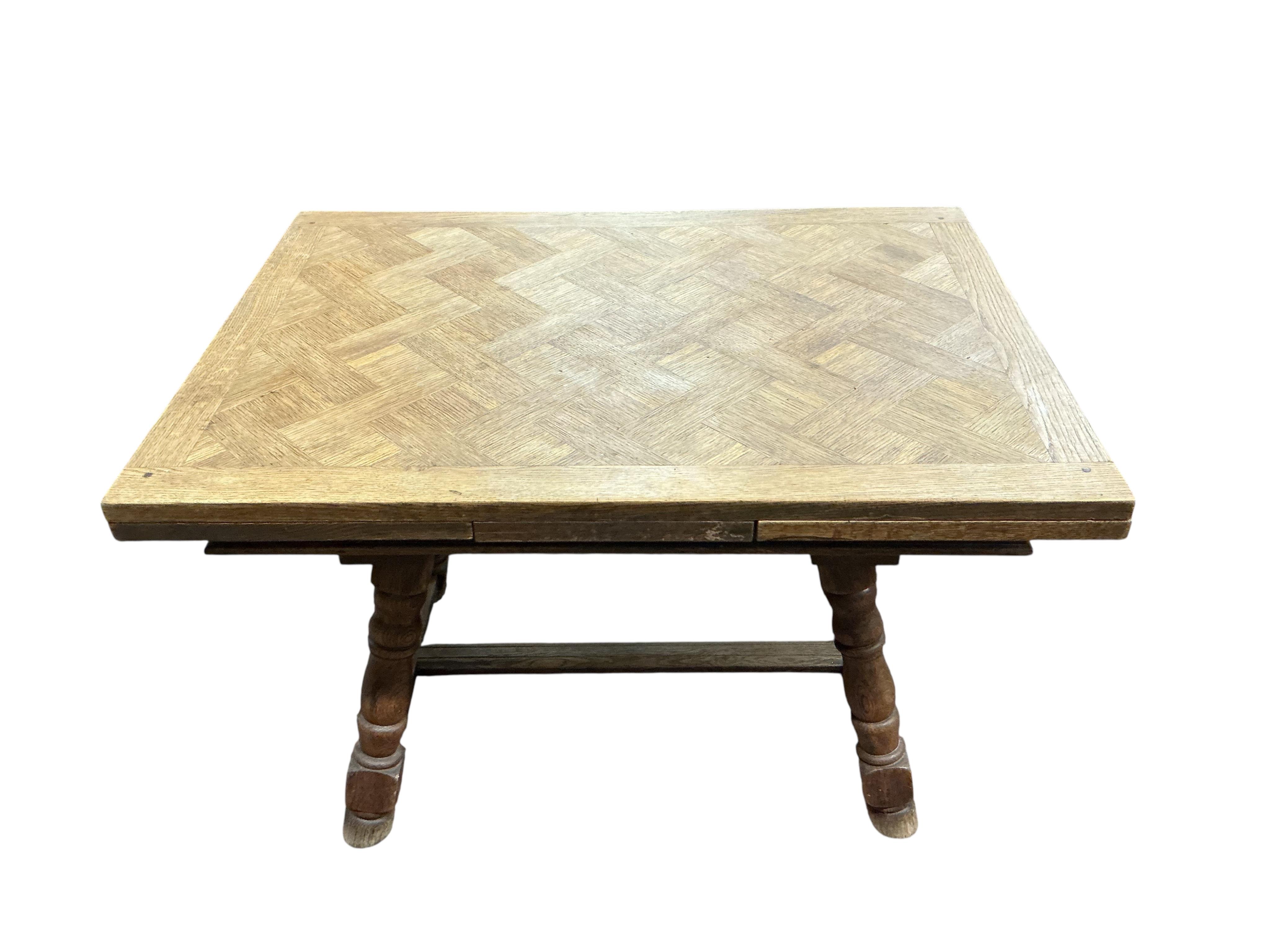 A small late 19th / early 20th century French parquetry oak draw leaf dining table, width 186cm extended, depth 79cm, height 74cm